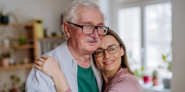Adult daughter hugging elderly father